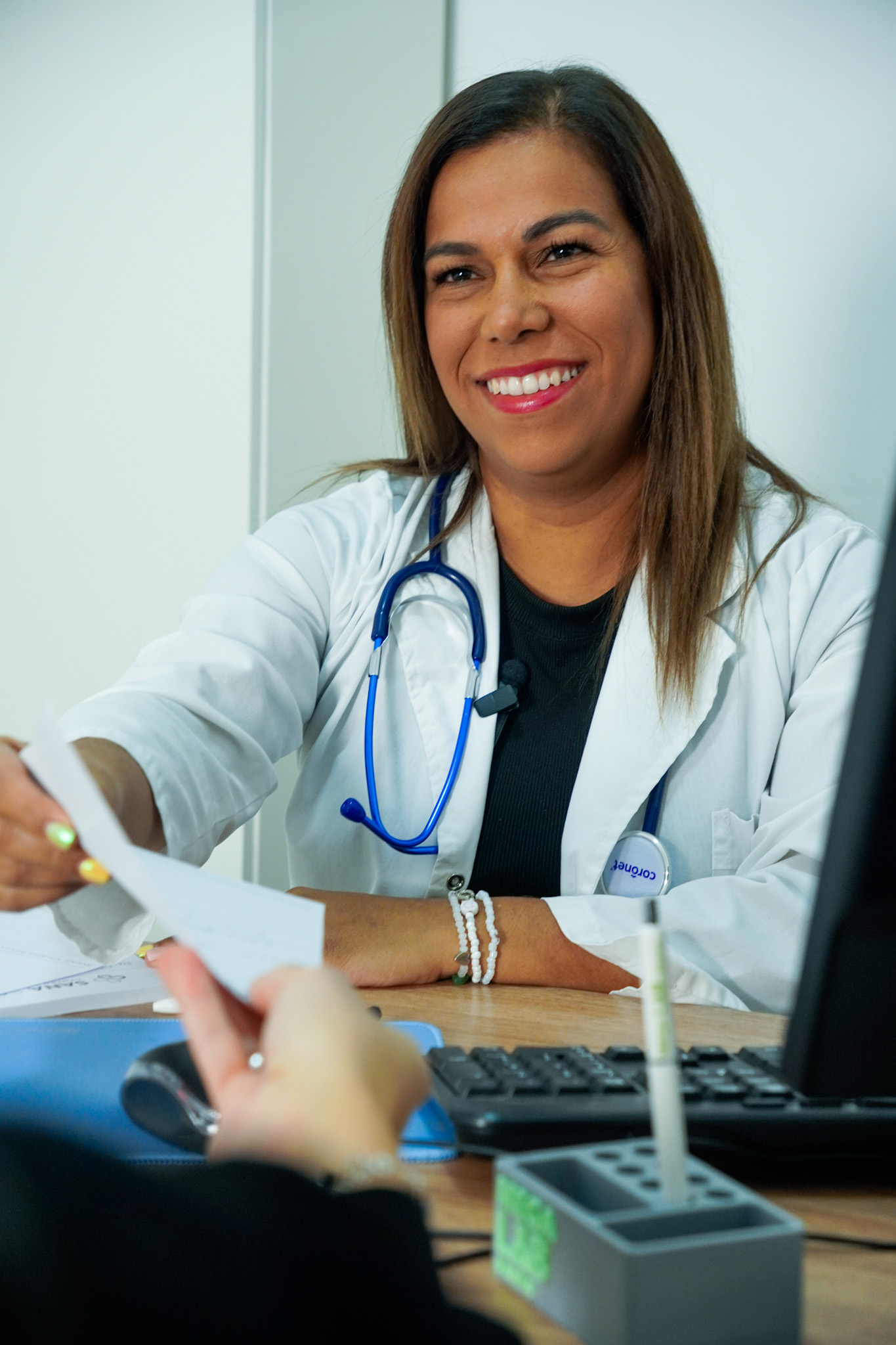 Médica de Sana Salud entregando una indicación durante la consulta.